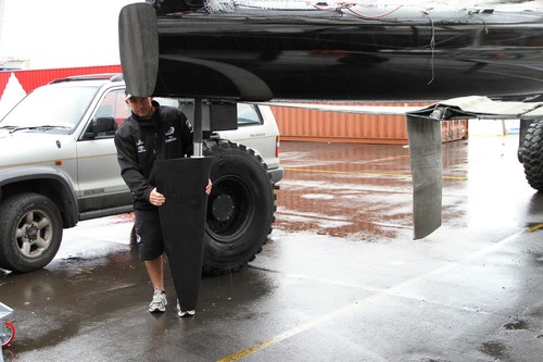 Ray Davies fits a rudder to Emirates Team NZ’s  SL332 © Richard Gladwell www.photosport.co.nz